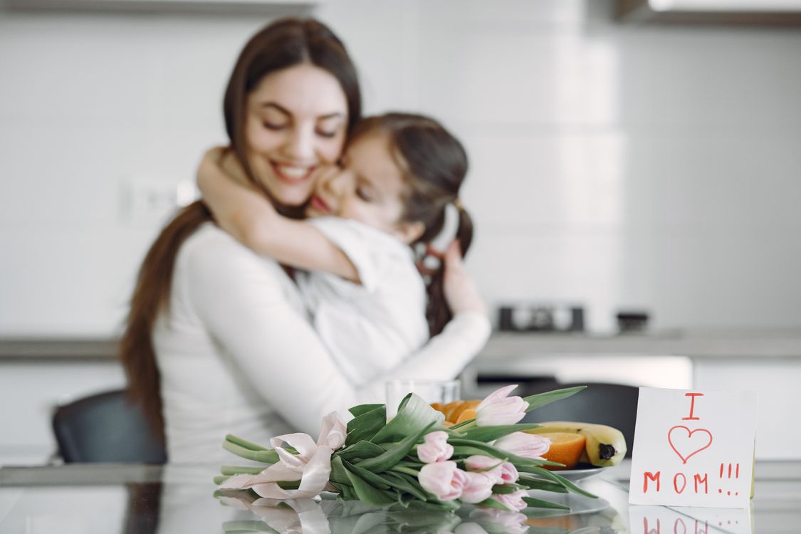 Une maman et son enfant avec des tulipes et un petit mot écrit à la main