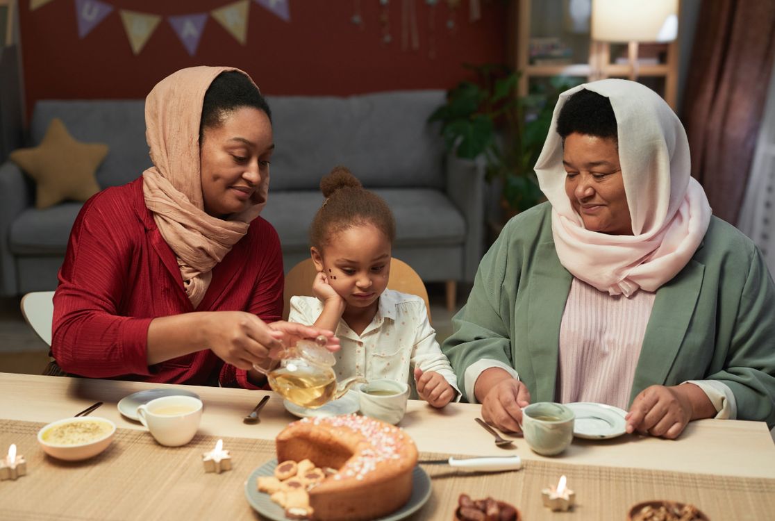 Une famille réunie autour de la table avec du thé et des gâteaux