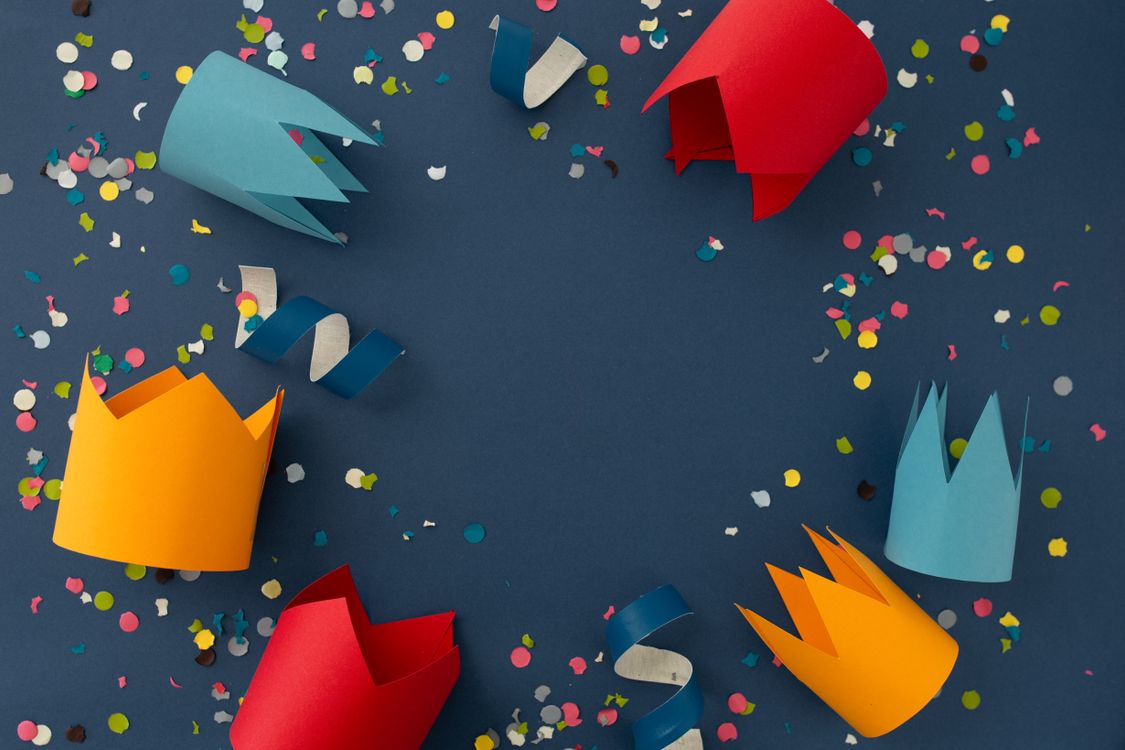 Des couronnes en papier posées au milieu de confettis colorés