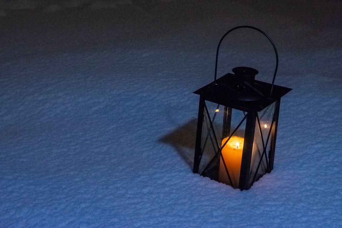 Une lanterne allumée posée dans la neige