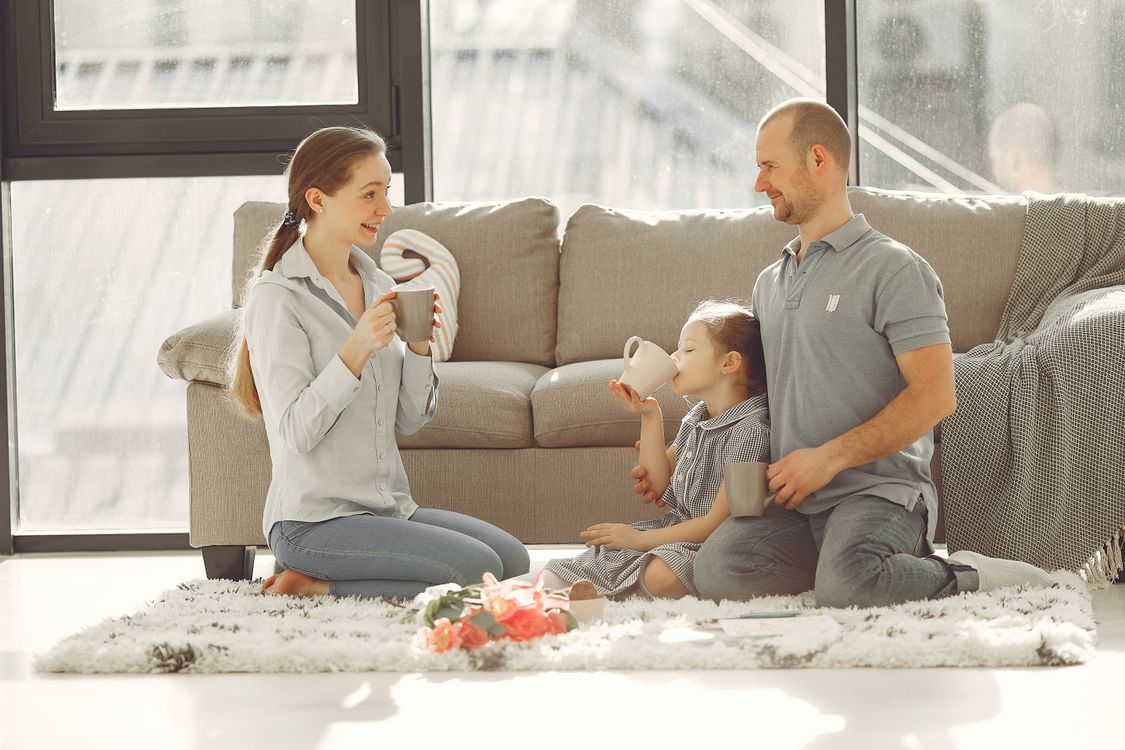 Famille qui rit ensemble sur le canapé à la maison, le moment où les souvenirs de vacances se partagent