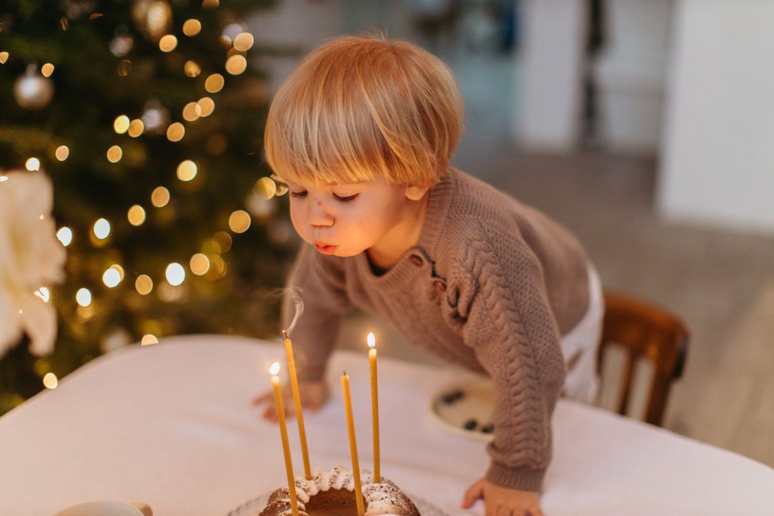Un enfant souffle les bougies d'un gâteau d'anniversaire